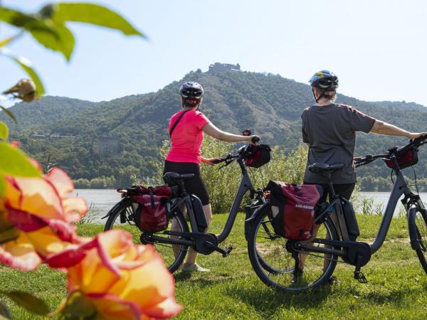 Radfahrer mit Burg in Visegrad im Hintergrund